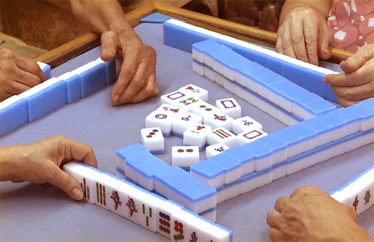 La gente gioca la versione tradizionale asiatica di Mahjong